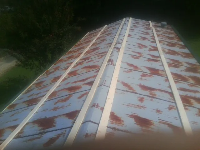 Rusted metal roof panels with new wood purlins before replacement — Storm Damage Roof Repair in Alberta by Roofing Brothers